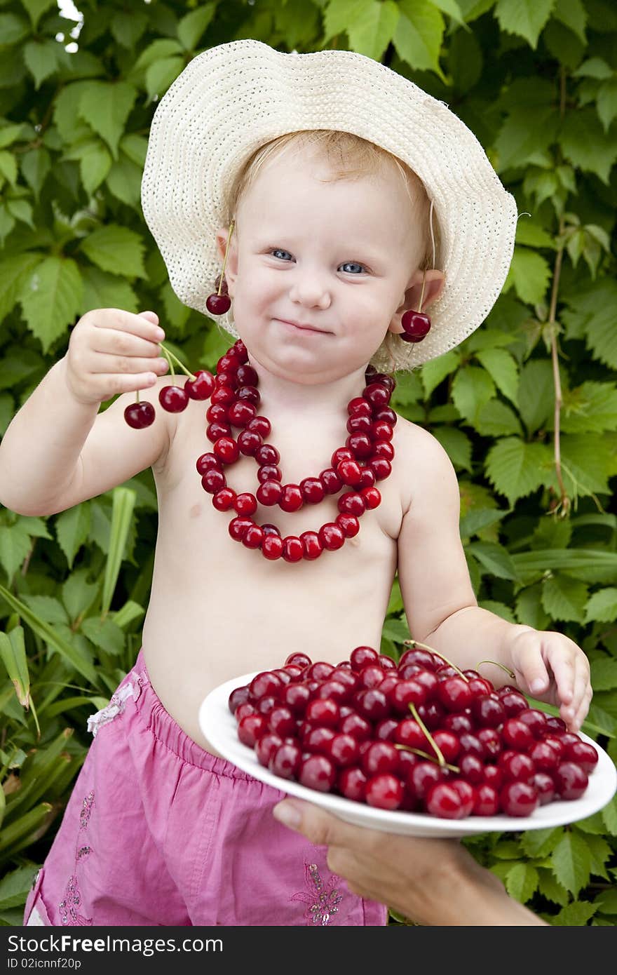 Small girl with red cherry beads and earrings