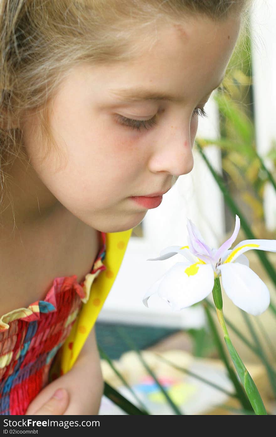 Little girl smelling a flower