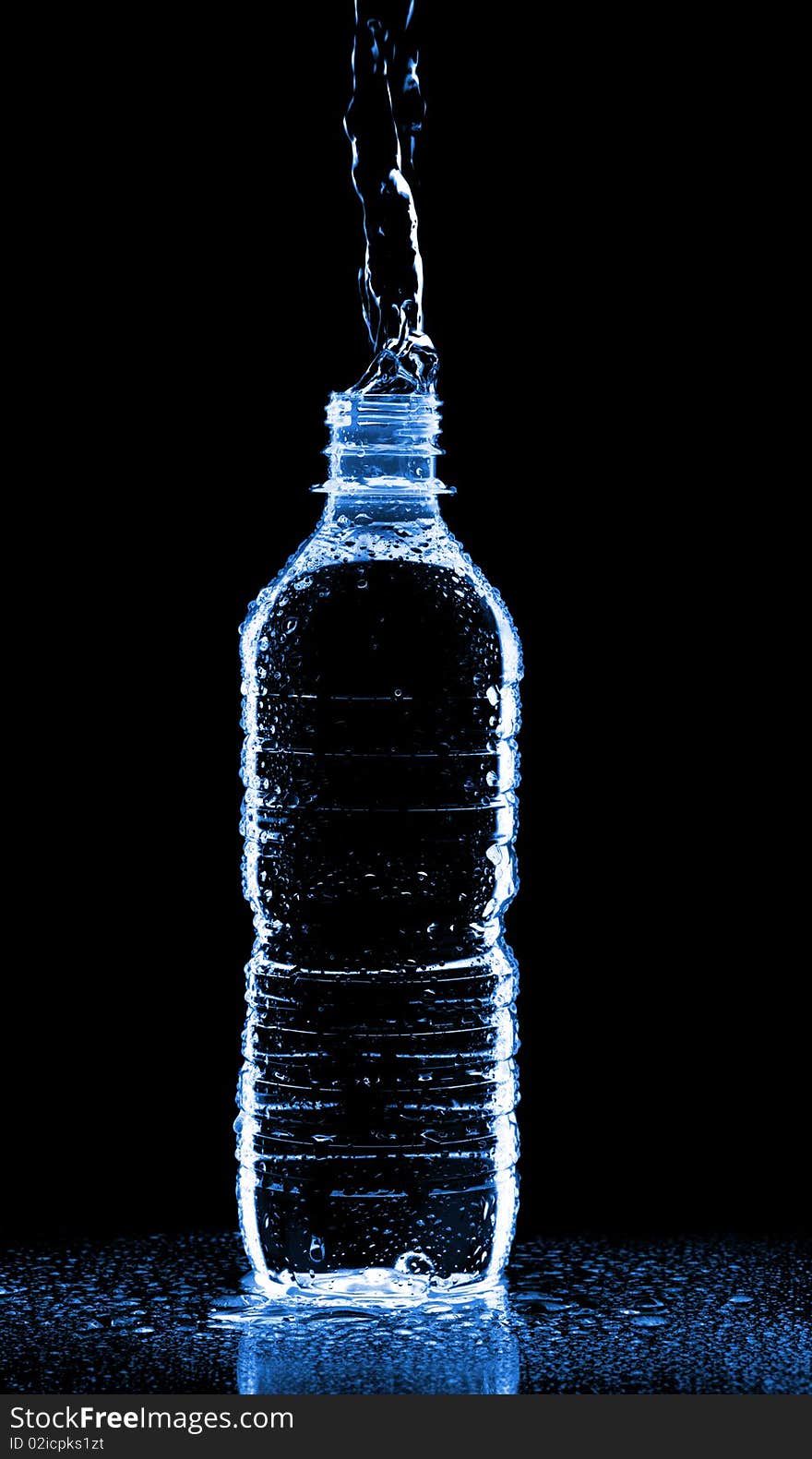 Water splashing from bottle isolated on black