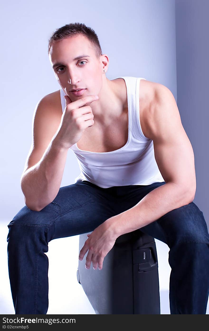 A trendy European man dressed in undershirt. Studio shot