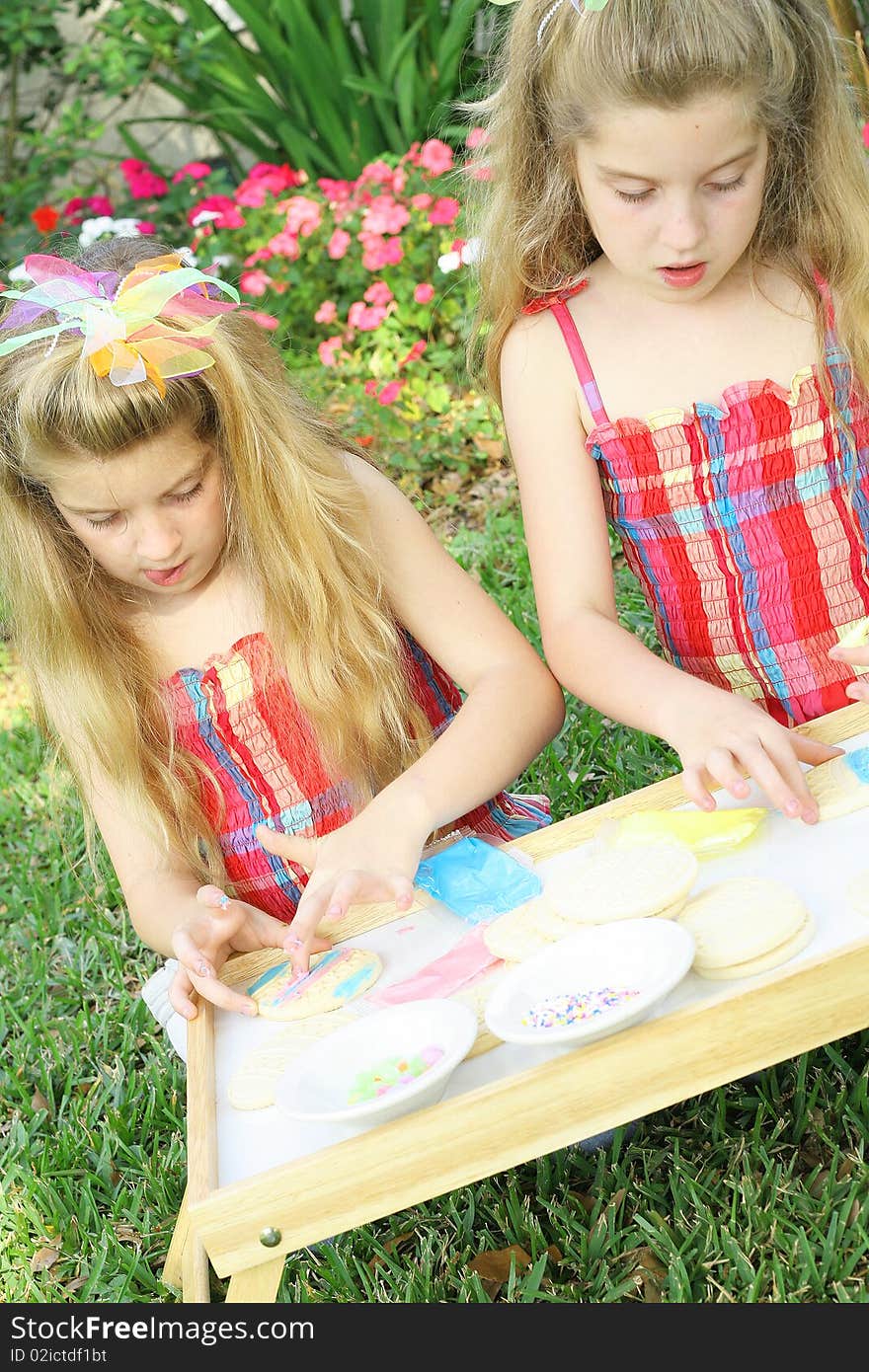 Little girls decorating cookies vertical