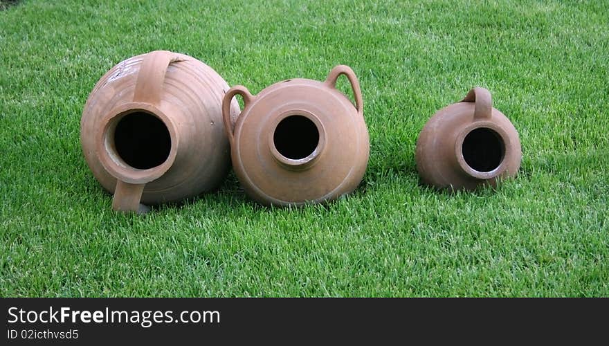 Three earthen potteries onto green grass. Three earthen potteries onto green grass.