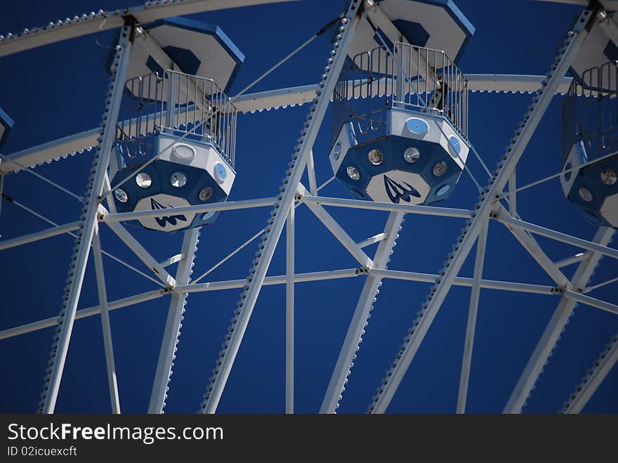 The carts that are up in the sky on a ferris wheel ride. The carts that are up in the sky on a ferris wheel ride.