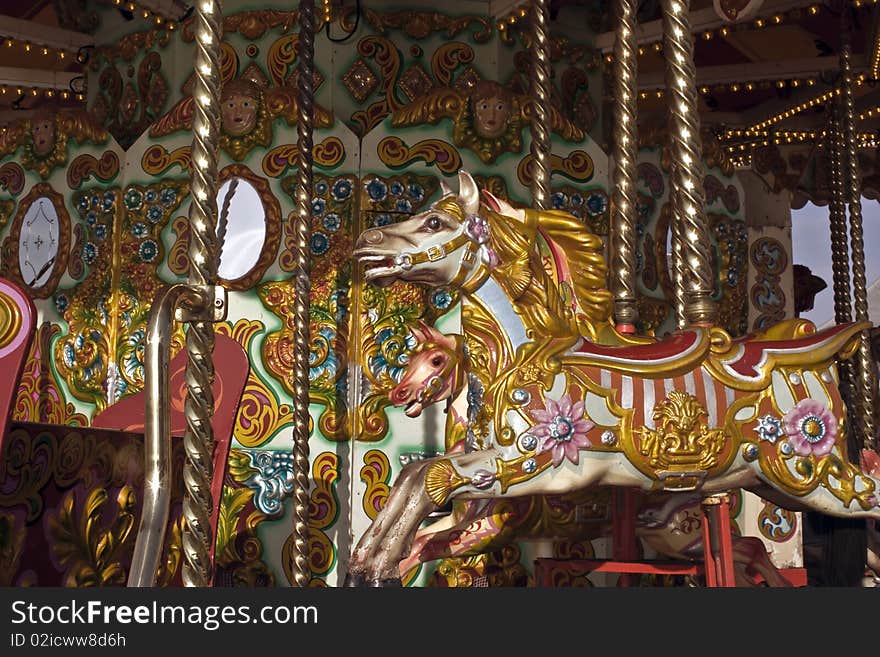 A brightly painted pony on a carousel on a sunny day. A brightly painted pony on a carousel on a sunny day