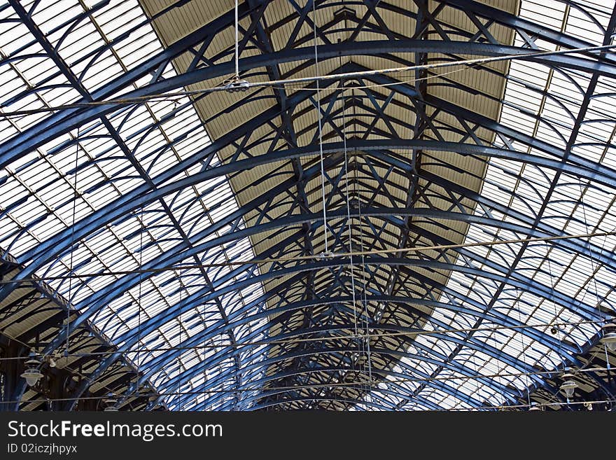 A glass and iron Victorian roof over a train station. A glass and iron Victorian roof over a train station