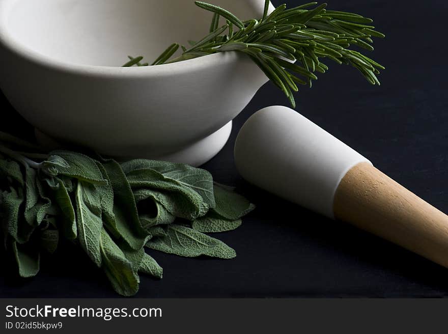 Mortar and Pestle With Fresh Herbs On A Slate Worktop