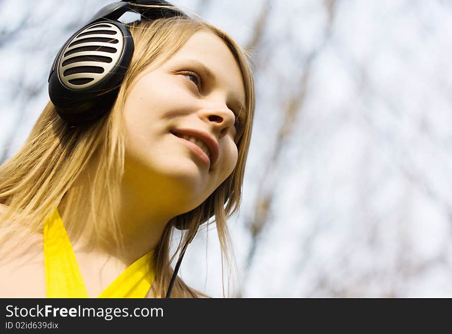 Blond woman smiling listening music in headphones