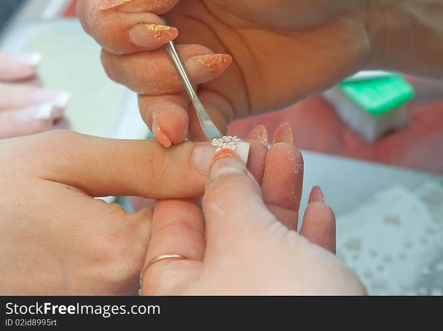 Manicurist applying clear polish on customer. Manicurist applying clear polish on customer