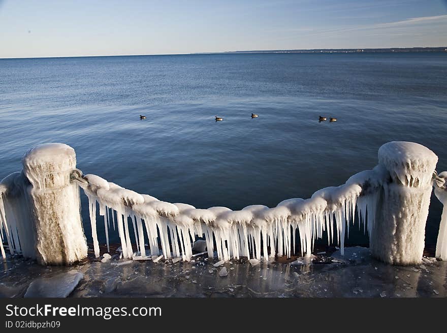 Texture of ice on the chain and blue water. Texture of ice on the chain and blue water