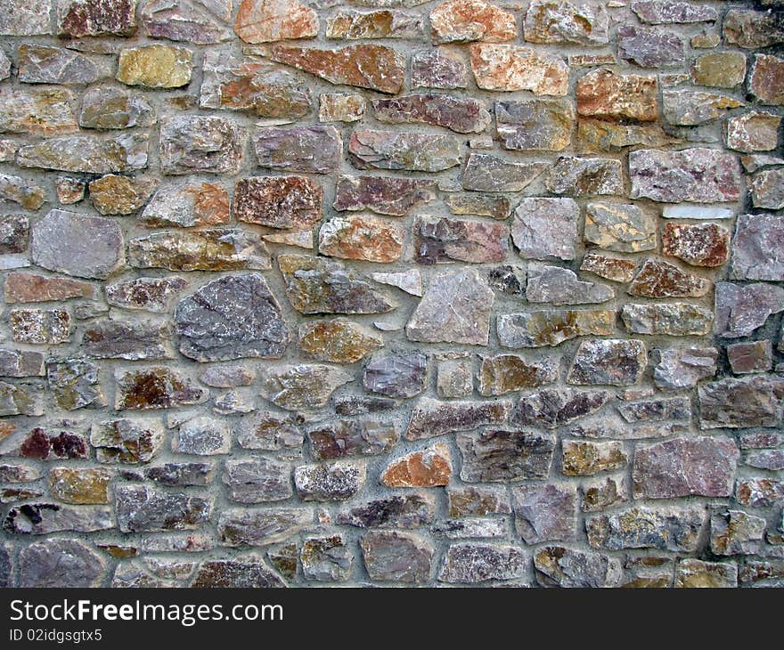 Multi colour stone wall pattern in sunny day, city Brixham UK. Multi colour stone wall pattern in sunny day, city Brixham UK