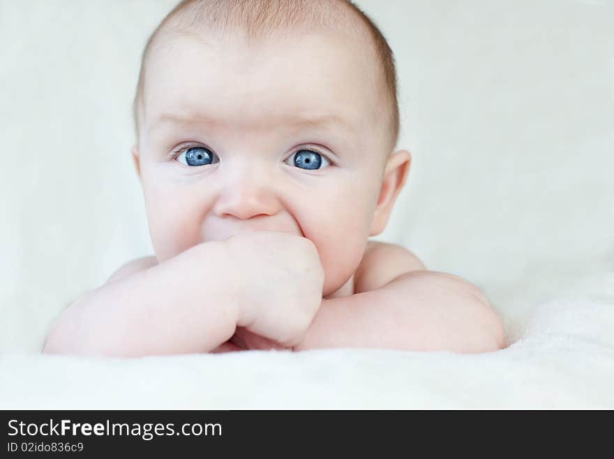 Baby laying on his tummy and chewing on his hands. Baby laying on his tummy and chewing on his hands.