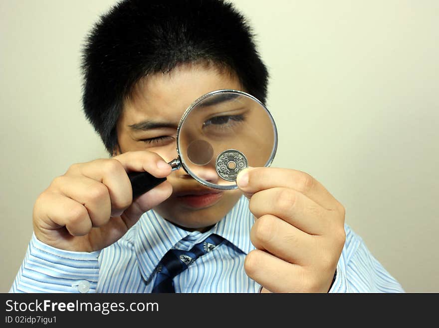 A Boy Examining A Coin