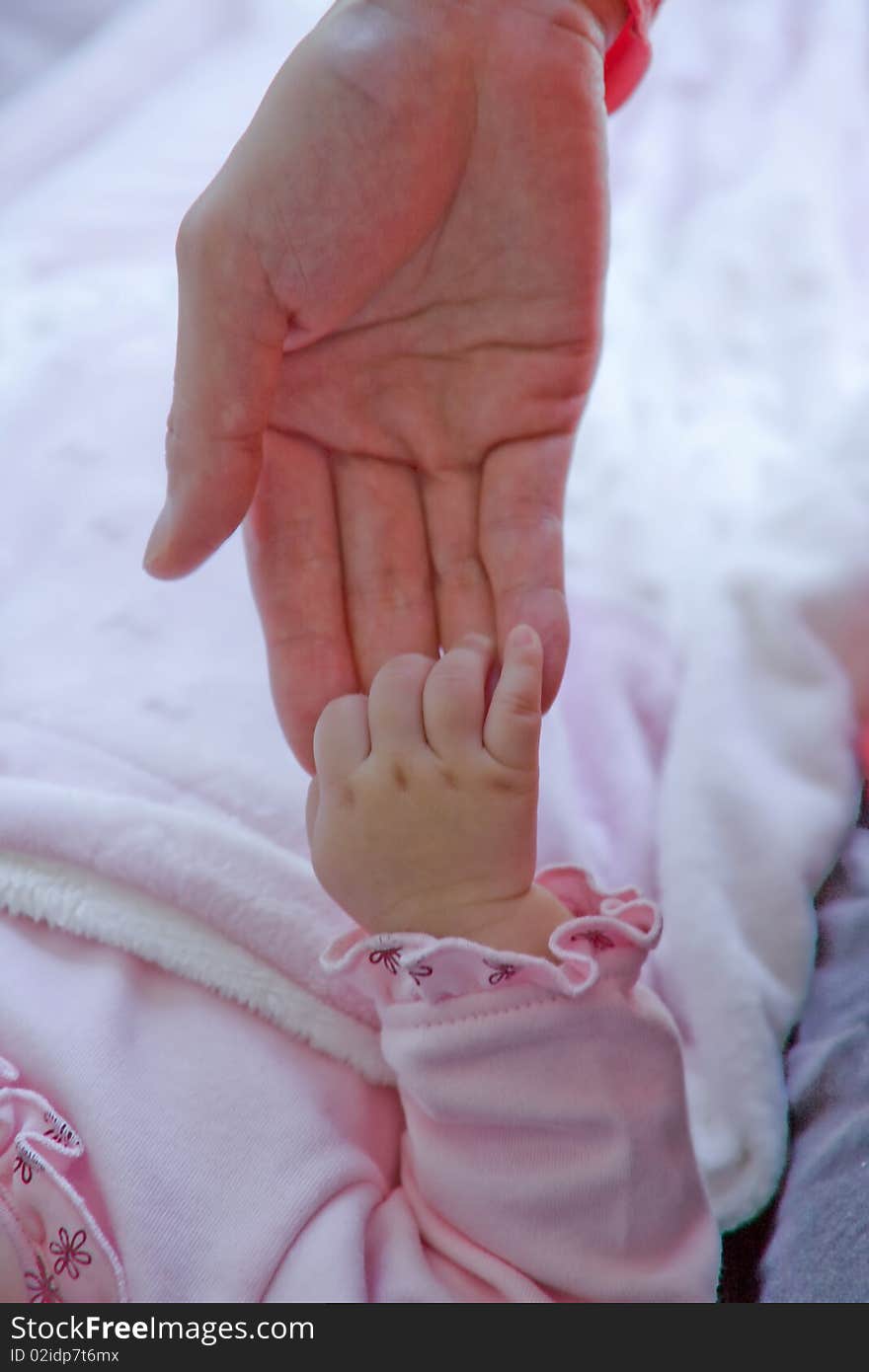 Baby's fingers hanging on mommy's hand. Baby's fingers hanging on mommy's hand