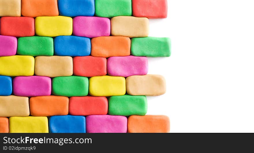 Wall background made of colorful child's play clay bricks with white copyspace. Wall background made of colorful child's play clay bricks with white copyspace