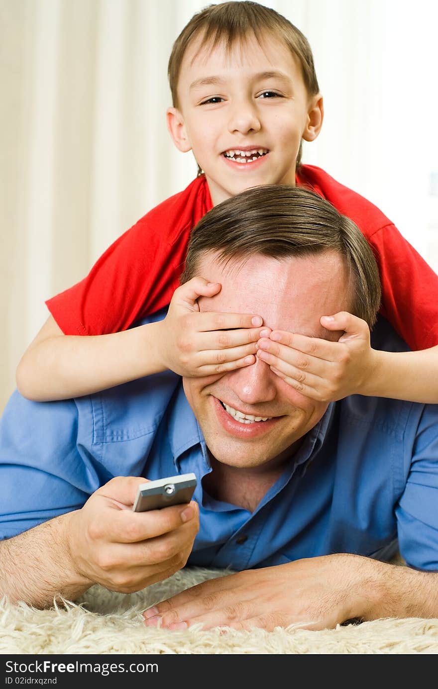 Son and father lying on the carpet