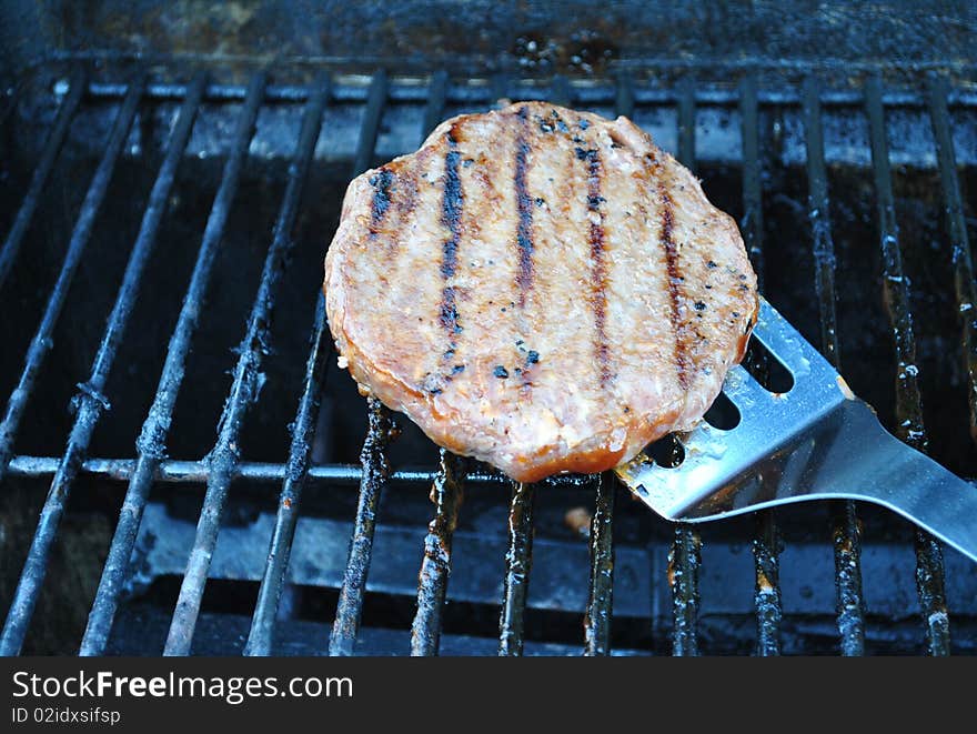 Flipping hamburger on grill