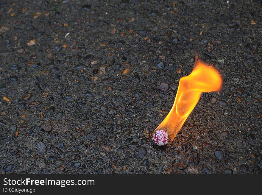 Fire ball burning on a black asphalt cement