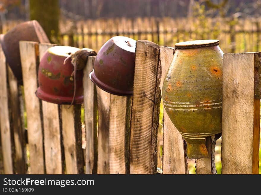 Old wooden boundary fence with nails on sunny day