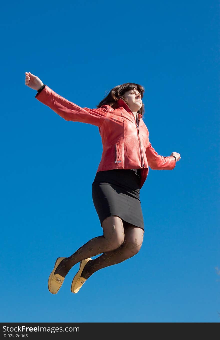 Jumping woman over blue sku