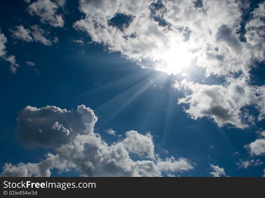 Blue sky with white cumulus and sun