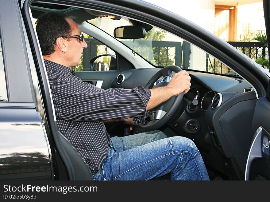 Man in new black car. Man in new black car.