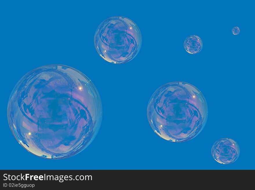 Many soap bubbles over a blue sky background