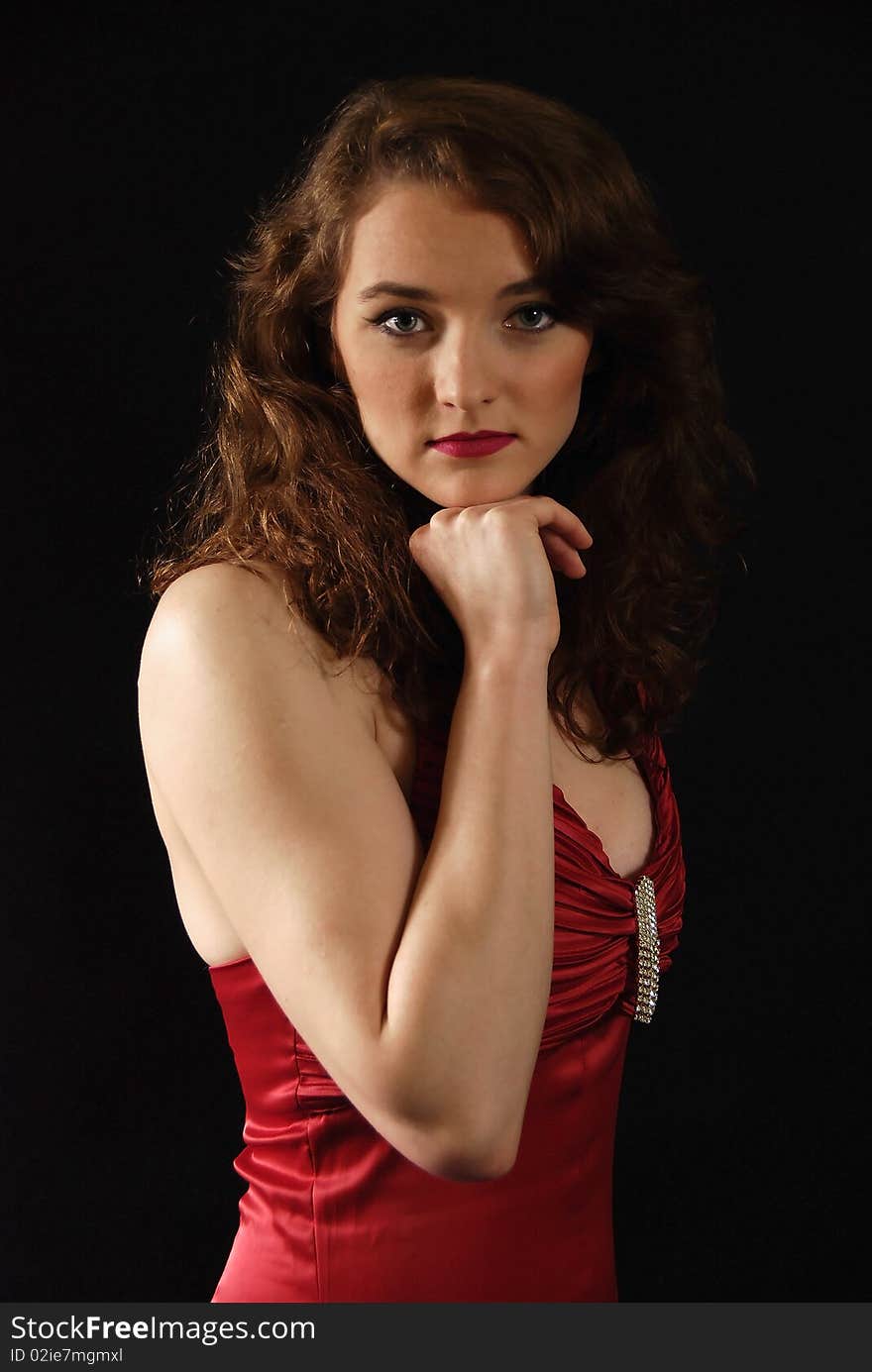 Portrait of the woman in the red dress on the black background