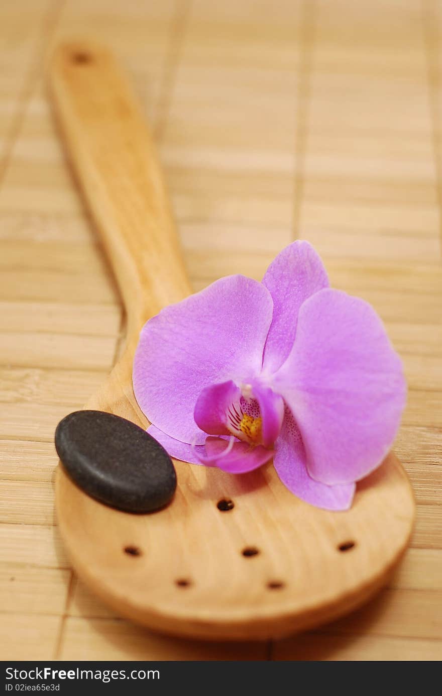 Wooden spoon with the stone and the flower of the orchid. Wooden spoon with the stone and the flower of the orchid