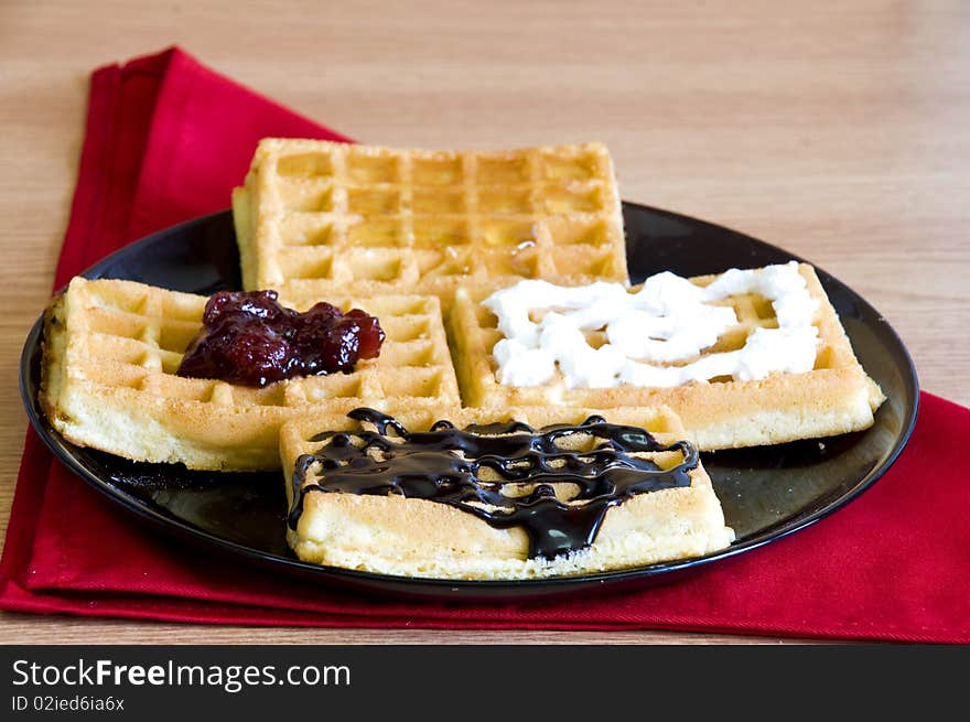 Breakfast waffles, jam, chocolate, honey and whip cream. Breakfast waffles, jam, chocolate, honey and whip cream