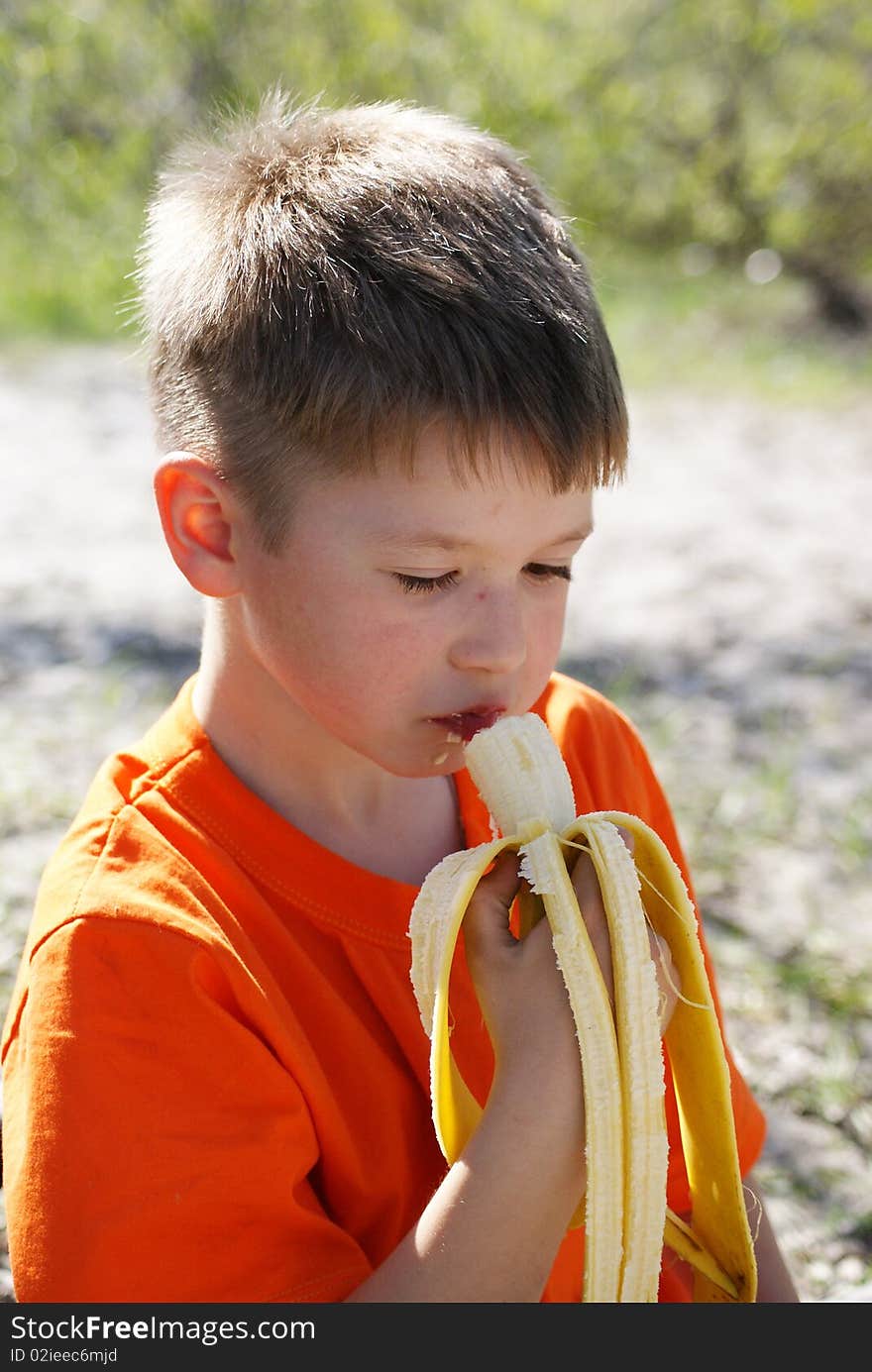 Boy with banan on the nature.