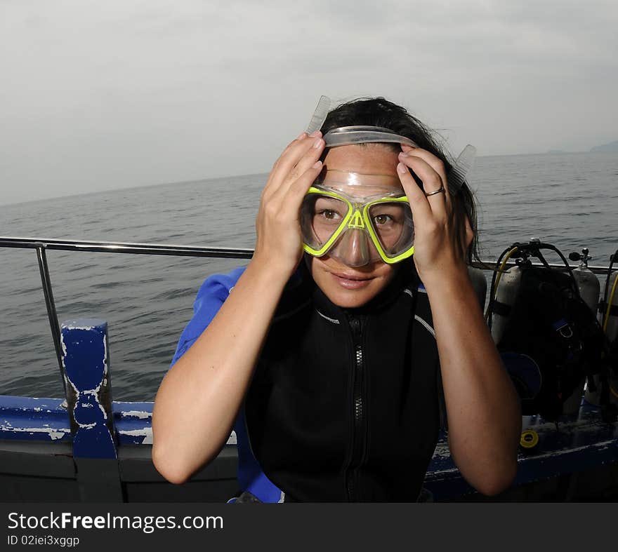 Scuba diver placing a mask on face. Scuba diver placing a mask on face