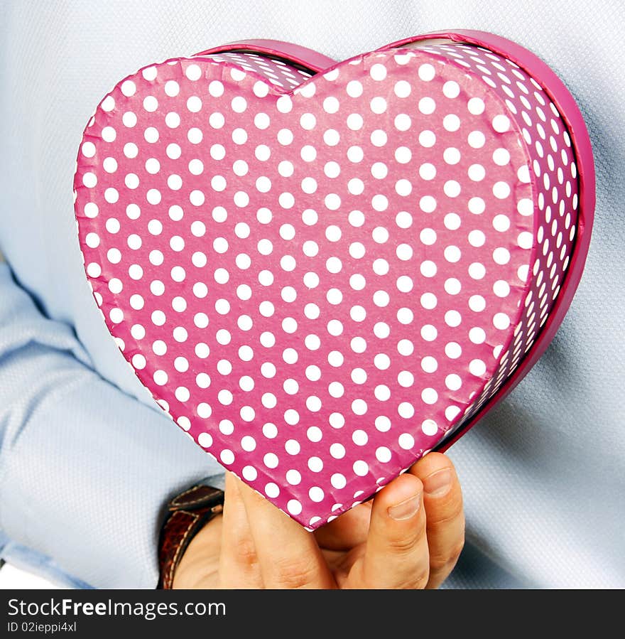 Businessman hiding a heart gift. Businessman hiding a heart gift