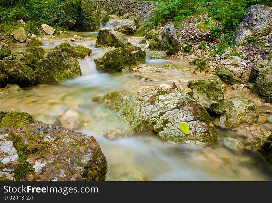 Water flows around stones in a long exposure. Water flows around stones in a long exposure.