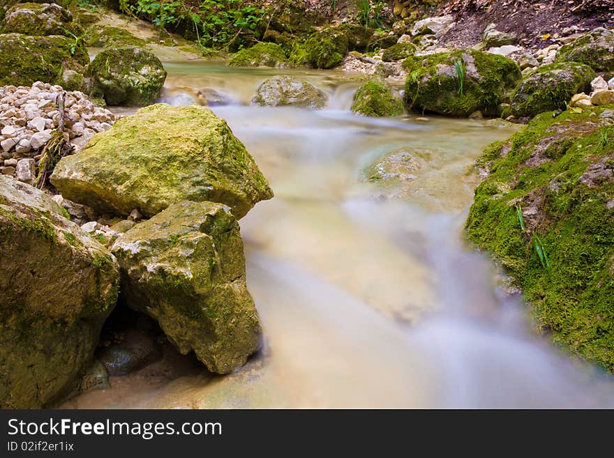 Water flows around stones in a long exposure. Water flows around stones in a long exposure.