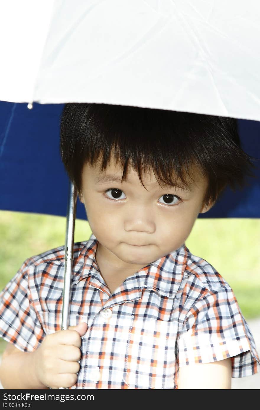 A young Asian boy holding an umbrella. A young Asian boy holding an umbrella