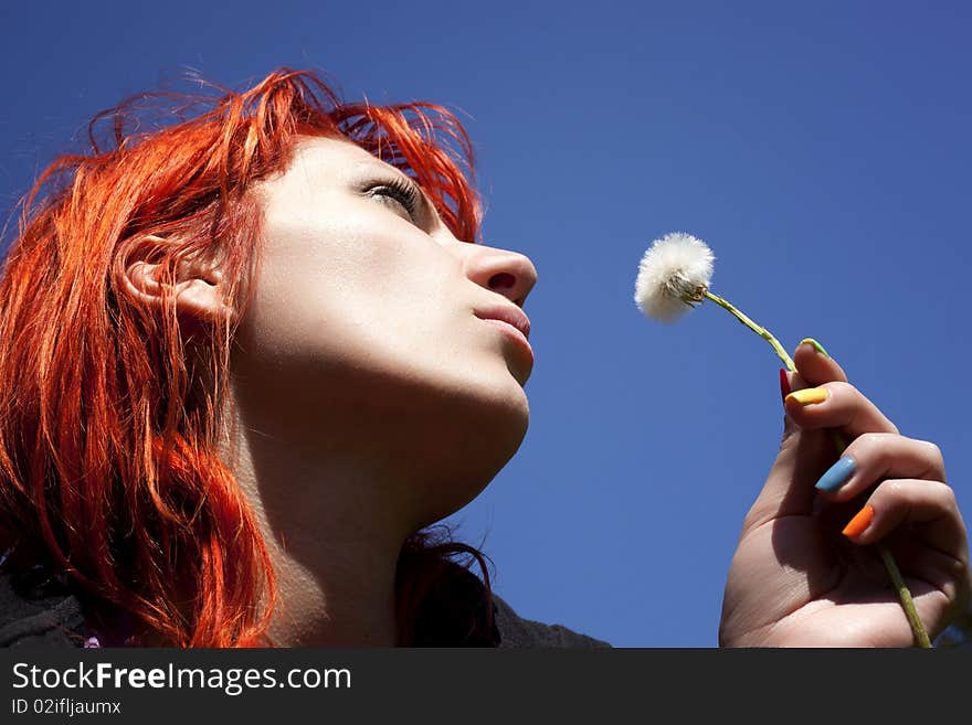 Beautiful image with a girl blowing dandelion's seeds. Beautiful image with a girl blowing dandelion's seeds