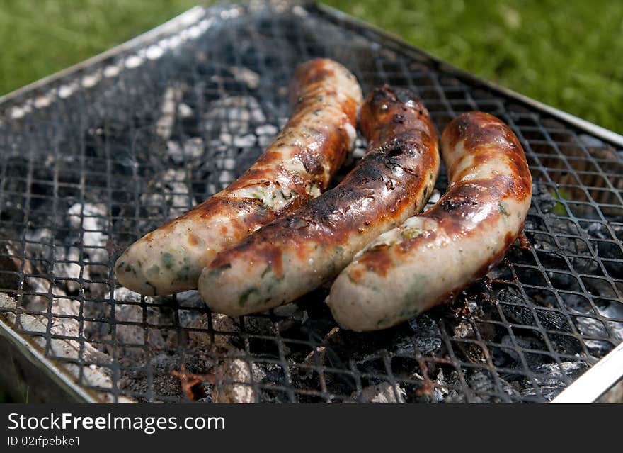 Burnt sausages on picnic grill