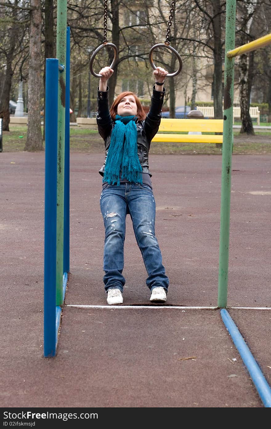 Sportive Girl Hanging On The Rings