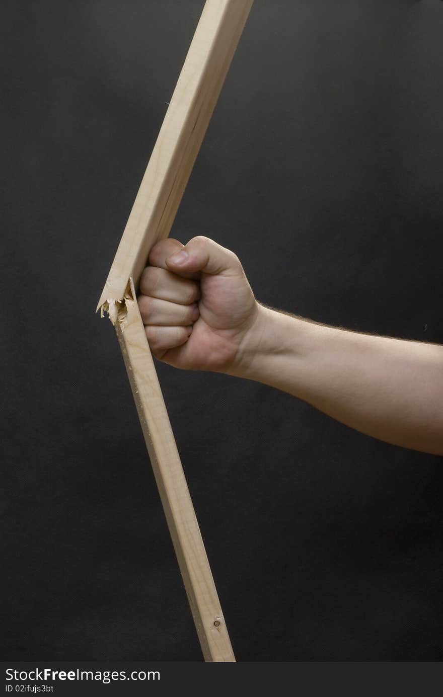 Men's hand breaking the wooden plank. Men's hand breaking the wooden plank