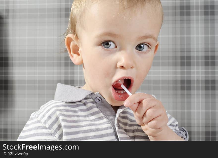 Boy eating his lollipop with mouth wide open. Boy eating his lollipop with mouth wide open