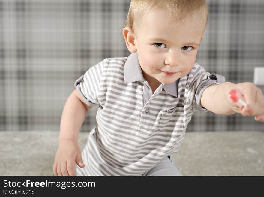 Boy eating his lollipop with mouth wide open. Boy eating his lollipop with mouth wide open