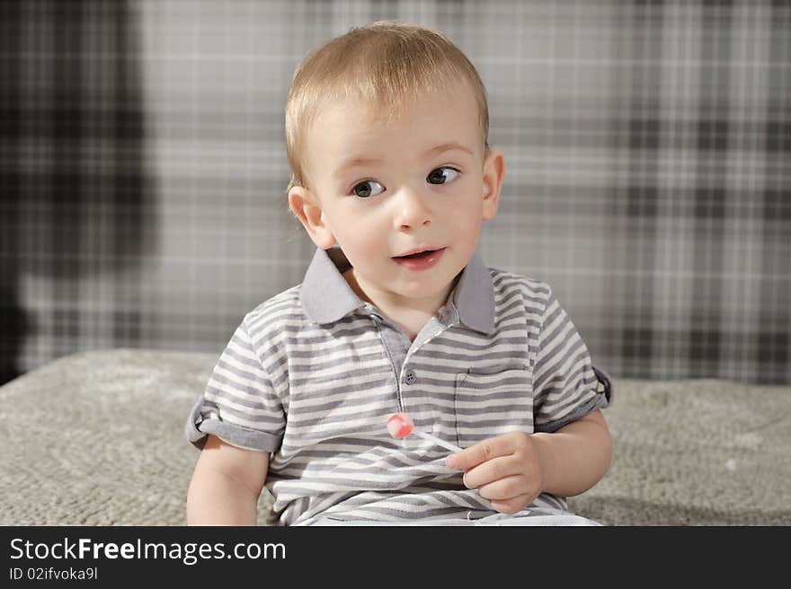 Little boy eating his lollipop and smiling. Little boy eating his lollipop and smiling