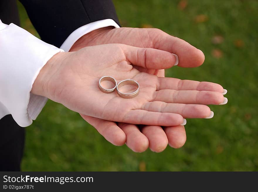 Bride and groom showing their wedding rings on their palms