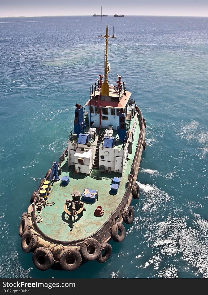 Tug boat working sailing vessel on sea