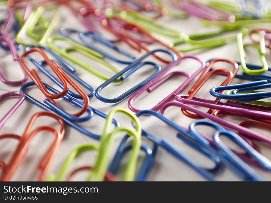 Colorful paper clips on a white piece of paper.