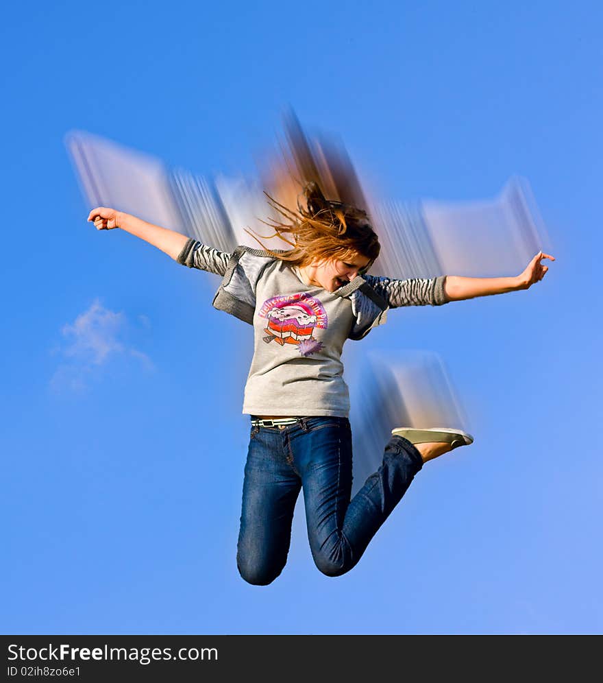 Beautiful girl on a blue sky whle jumping. Beautiful girl on a blue sky whle jumping