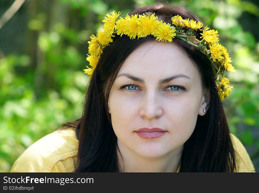 Wreath on a head of the girl sitting in a wood