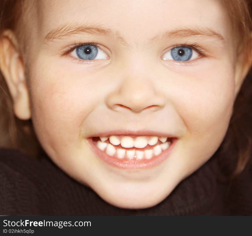 Beautiful little girl happily smiling closeup. Beautiful little girl happily smiling closeup