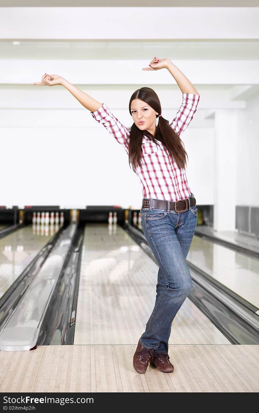 The young girl rejoices to a successful throw in bowling. The young girl rejoices to a successful throw in bowling