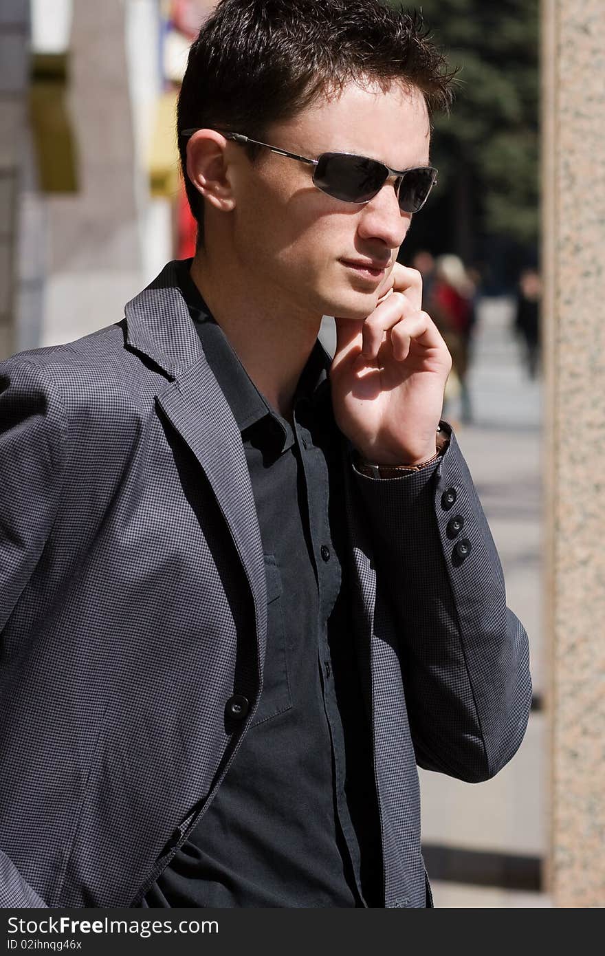 Businessman In Sunglasses Talks On Mobile Phone